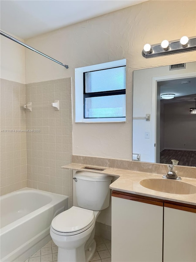 bathroom featuring tile patterned flooring, washtub / shower combination, visible vents, and vanity