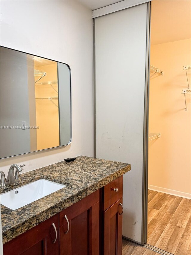 empty room featuring a ceiling fan, dark wood-style flooring, and baseboards