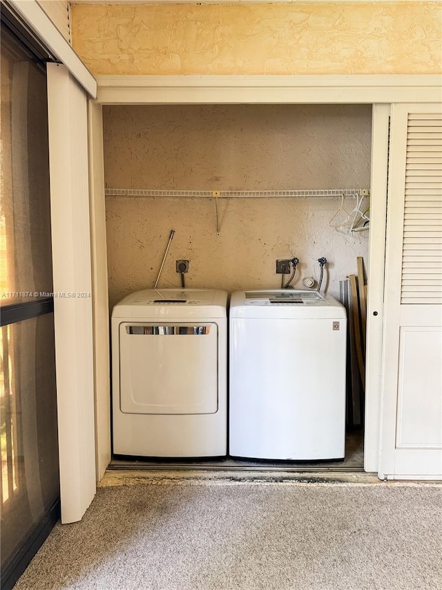 clothes washing area with separate washer and dryer and carpet floors