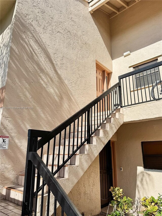 stairs with a textured wall and a high ceiling