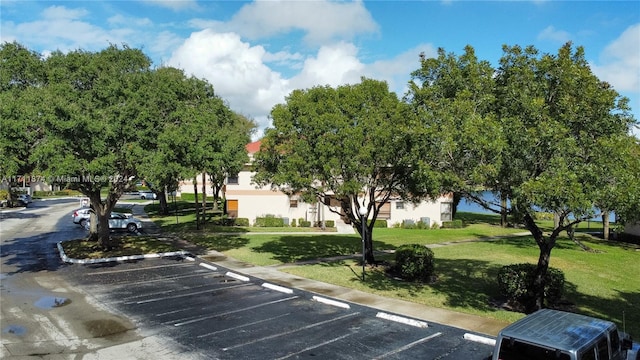 view of vehicle parking with a lawn