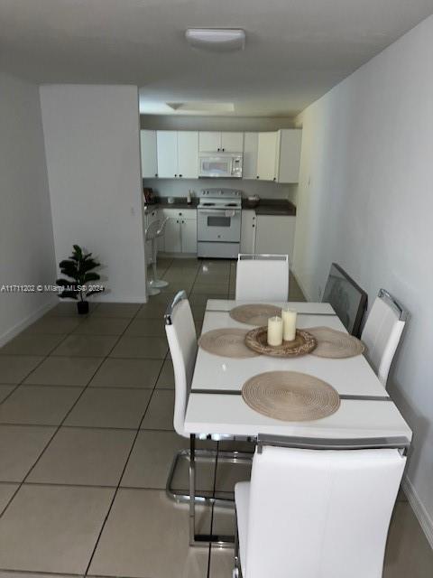 dining space with dark tile patterned flooring