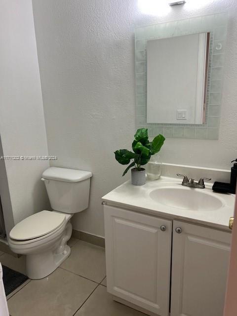 bathroom with tile patterned flooring, vanity, and toilet