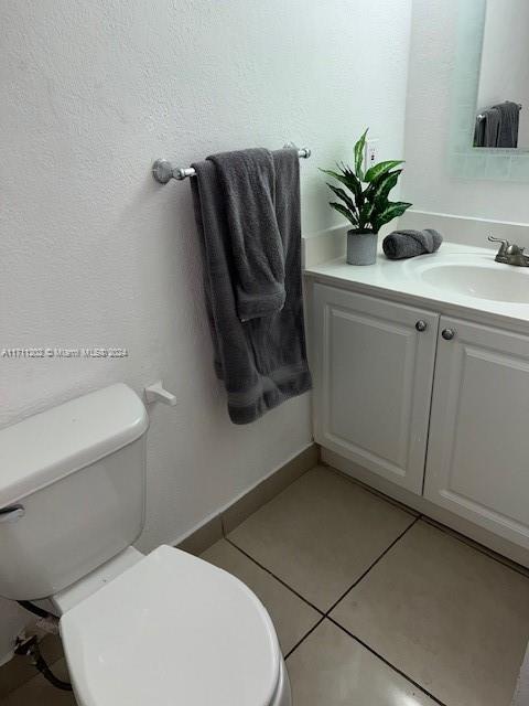 bathroom featuring tile patterned flooring, vanity, and toilet