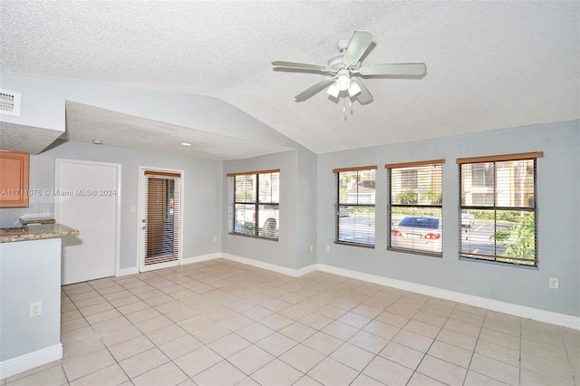 interior space with a healthy amount of sunlight, a textured ceiling, ceiling fan, and lofted ceiling