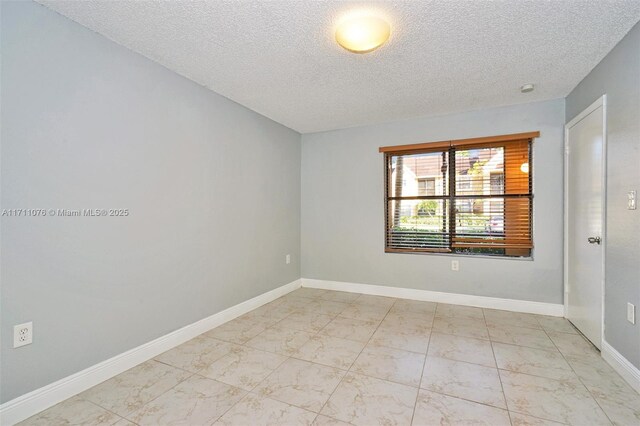 unfurnished room with a textured ceiling