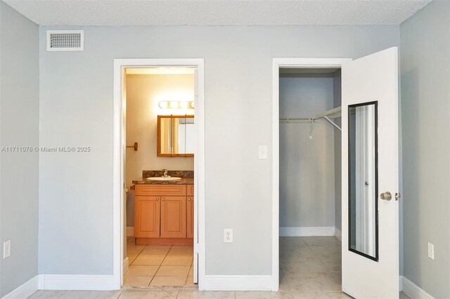 bathroom with tiled shower / bath combo, toilet, and a textured ceiling