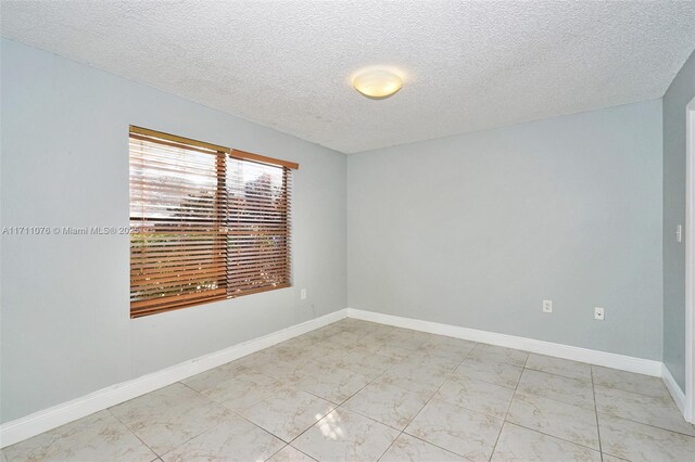 unfurnished room with a textured ceiling