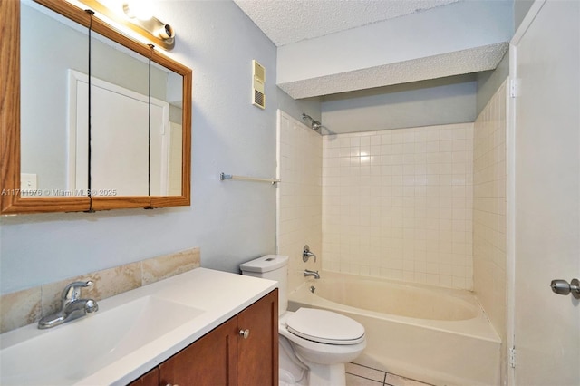 full bathroom with tile patterned floors, toilet, tiled shower / bath, a textured ceiling, and vanity