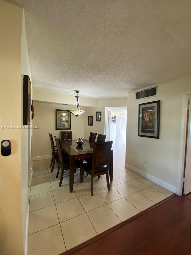 tiled dining room with a textured ceiling