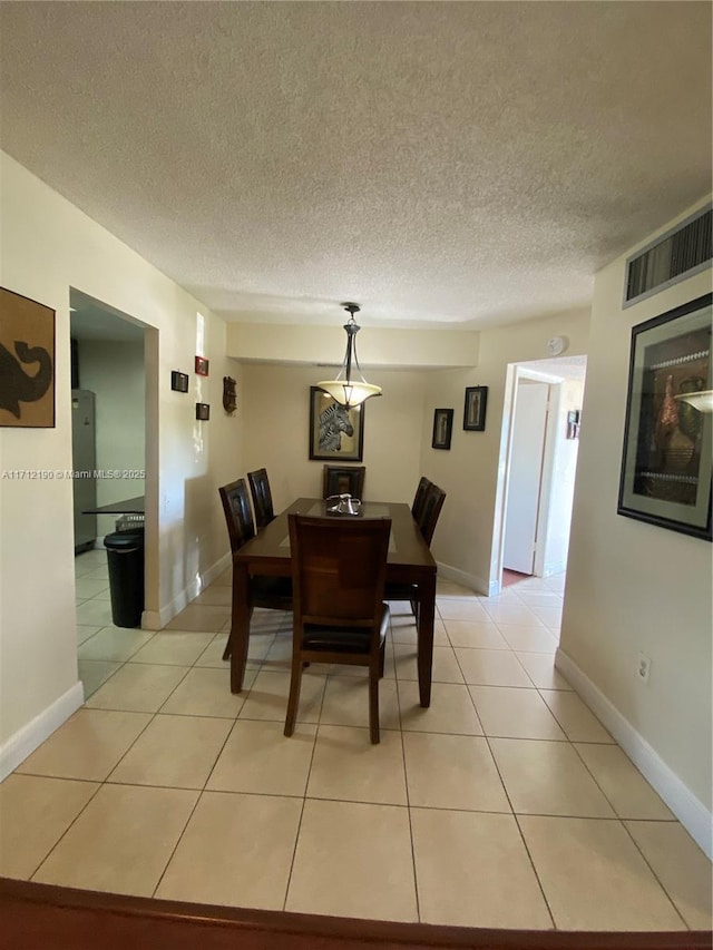 dining area with light tile patterned flooring and a textured ceiling