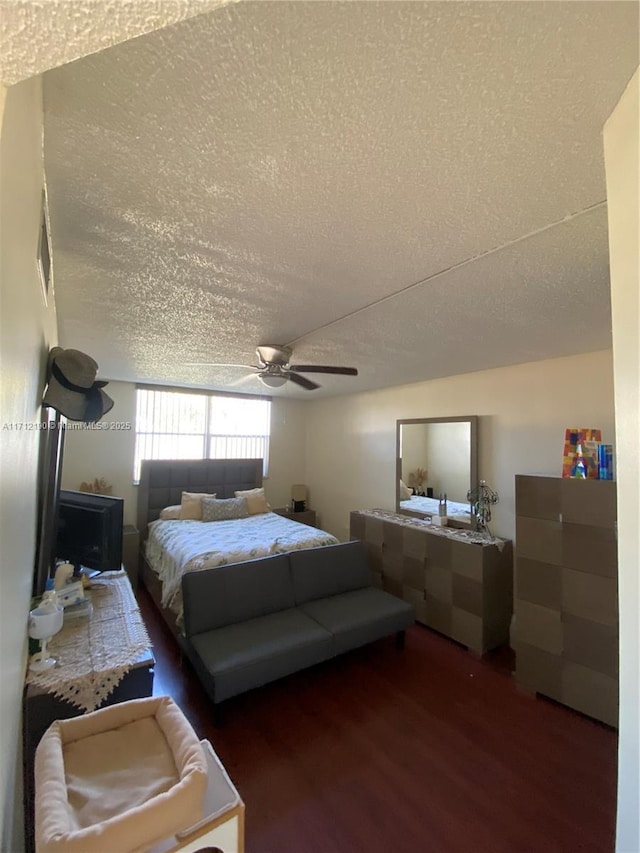 bedroom with a textured ceiling, dark hardwood / wood-style floors, and ceiling fan