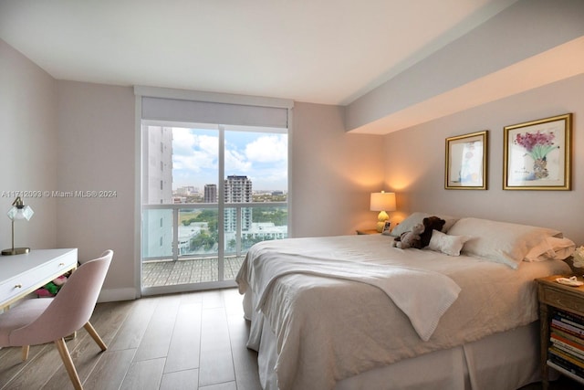 bedroom with access to outside and light wood-type flooring