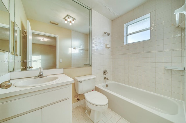 full bathroom with tile patterned floors, vanity, tiled shower / bath combo, and toilet