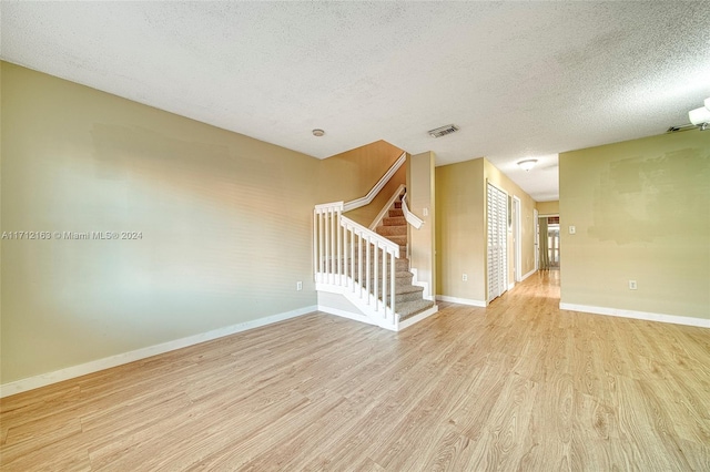 empty room featuring a textured ceiling and light wood-type flooring