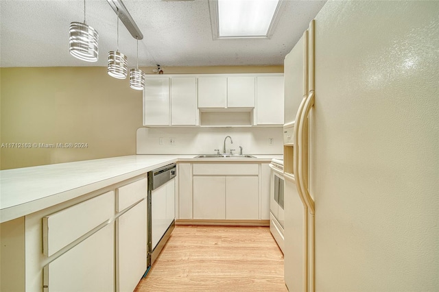 kitchen featuring pendant lighting, white cabinets, light wood-type flooring, and sink