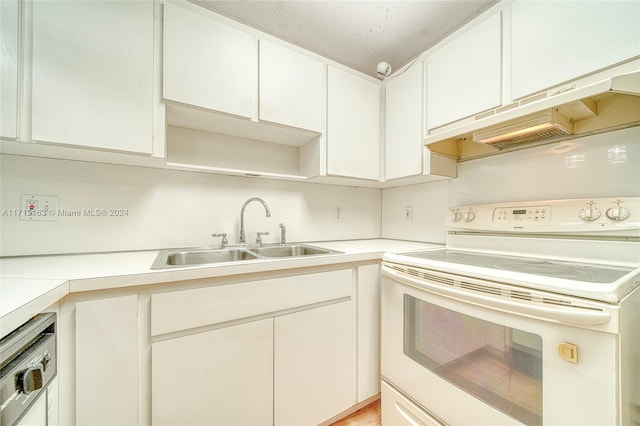 kitchen with white range with electric cooktop, white cabinetry, sink, and exhaust hood