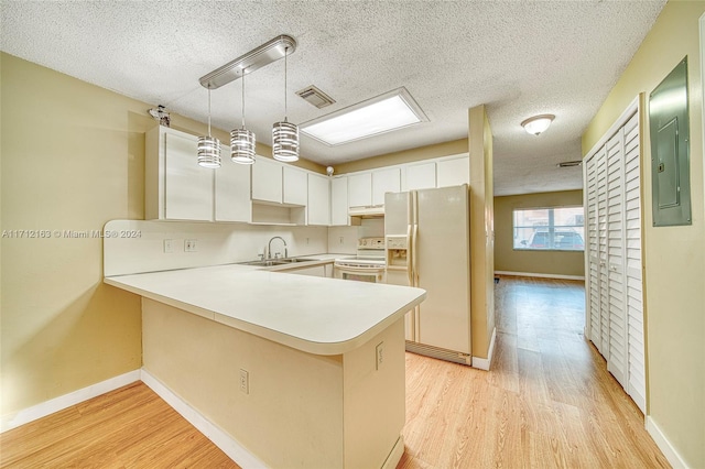 kitchen featuring kitchen peninsula, white appliances, pendant lighting, light hardwood / wood-style flooring, and white cabinetry