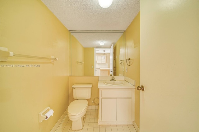 bathroom featuring tile patterned flooring, vanity, toilet, and a textured ceiling