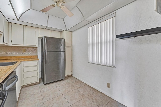 kitchen with sink, ceiling fan, light tile patterned floors, tasteful backsplash, and stainless steel appliances