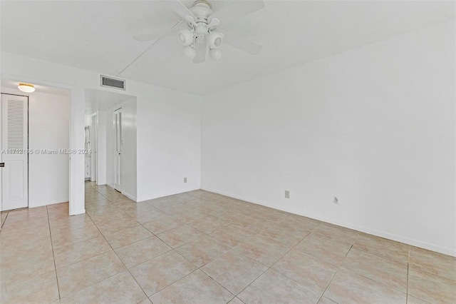 tiled spare room featuring ceiling fan