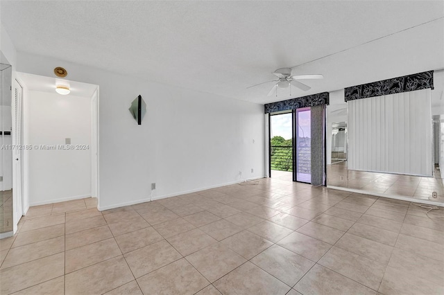 tiled empty room featuring a textured ceiling and ceiling fan