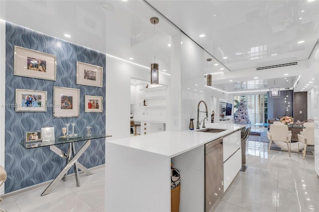 kitchen with white cabinets, a spacious island, sink, stainless steel dishwasher, and decorative light fixtures