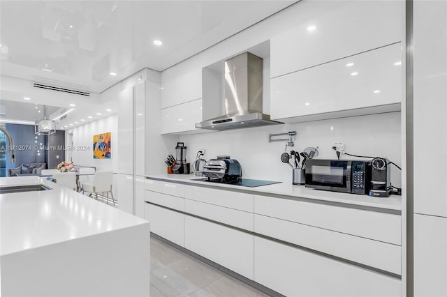 kitchen featuring white cabinets, sink, wall chimney exhaust hood, and black appliances