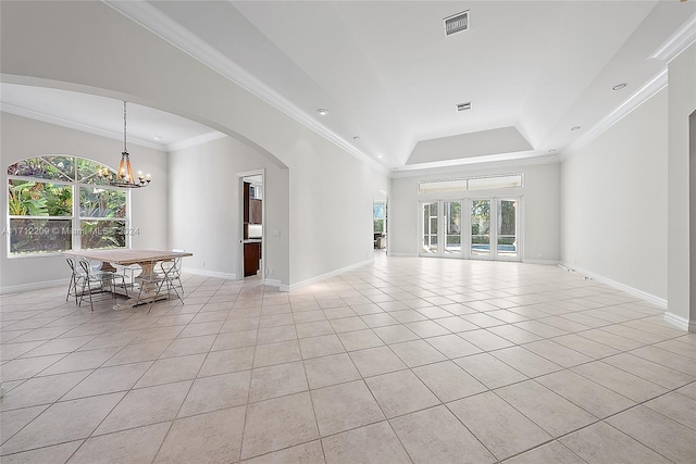 interior space featuring ornamental molding, a tray ceiling, and a chandelier