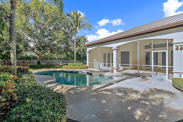 view of swimming pool featuring a sunroom and a patio