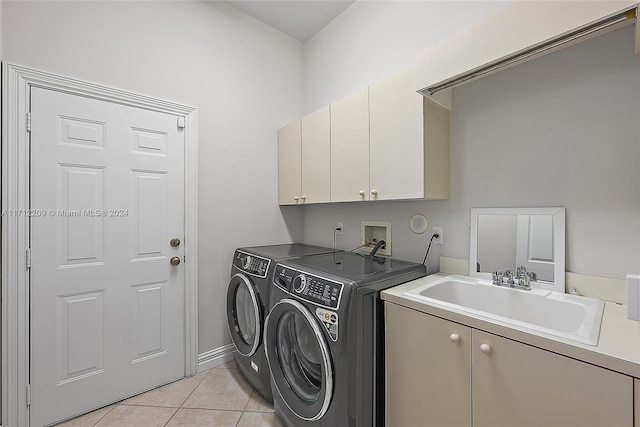 washroom featuring washer and clothes dryer, sink, light tile patterned flooring, and cabinets