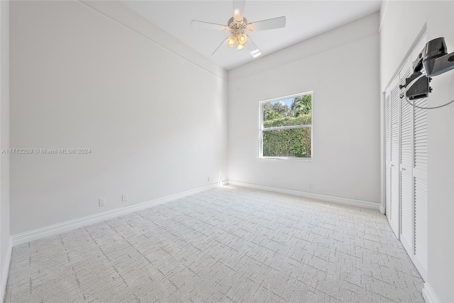 unfurnished bedroom with a closet, light colored carpet, and ceiling fan