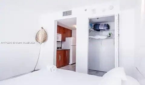 bedroom featuring white fridge and a closet