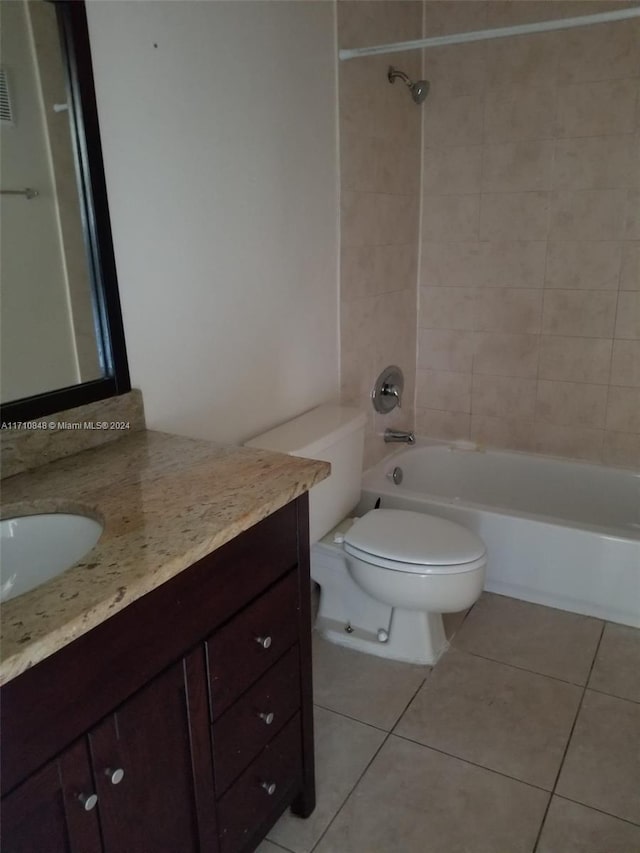 full bathroom with tiled shower / bath, tile patterned flooring, vanity, and toilet