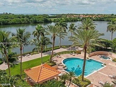 view of pool featuring a patio area and a water view