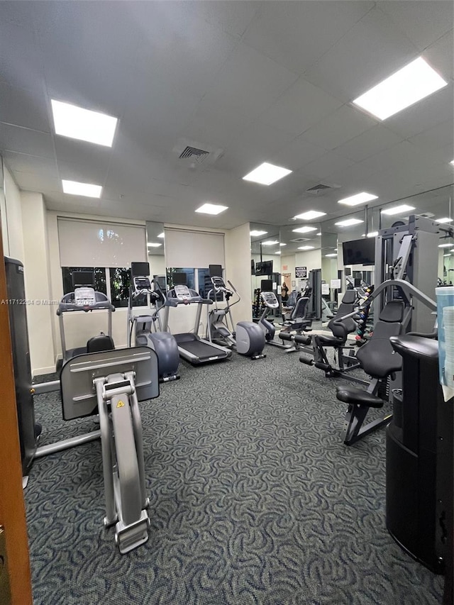 workout area with carpet flooring and a paneled ceiling