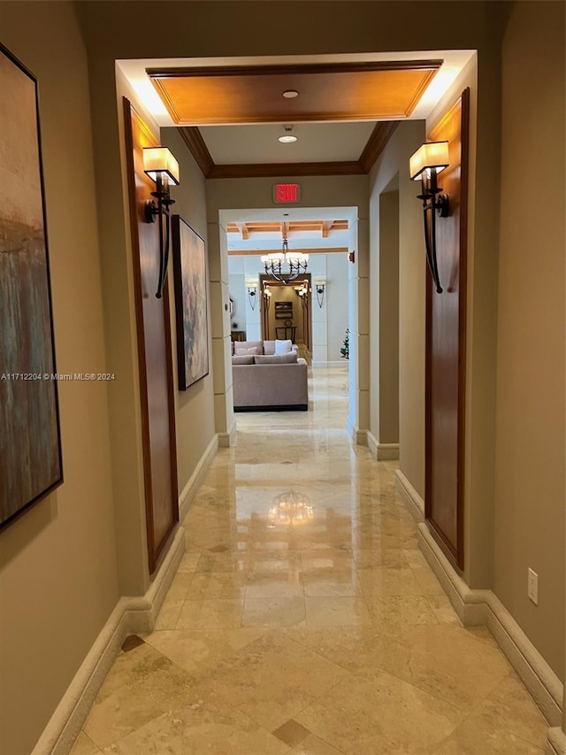 corridor featuring an inviting chandelier and ornamental molding