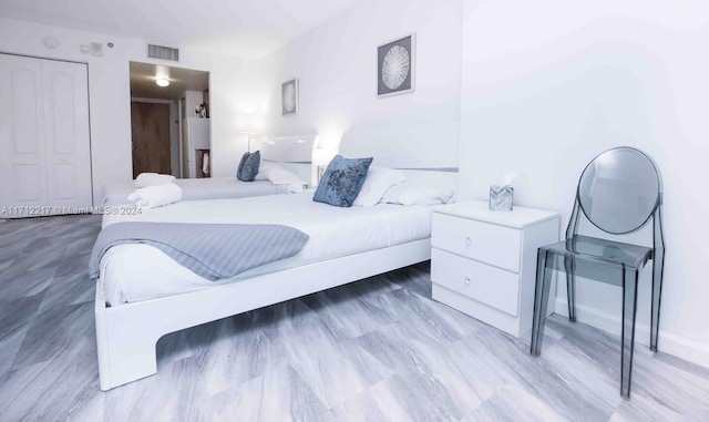 bedroom with light hardwood / wood-style flooring and a closet