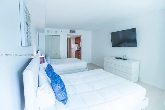 bedroom featuring a closet and white refrigerator