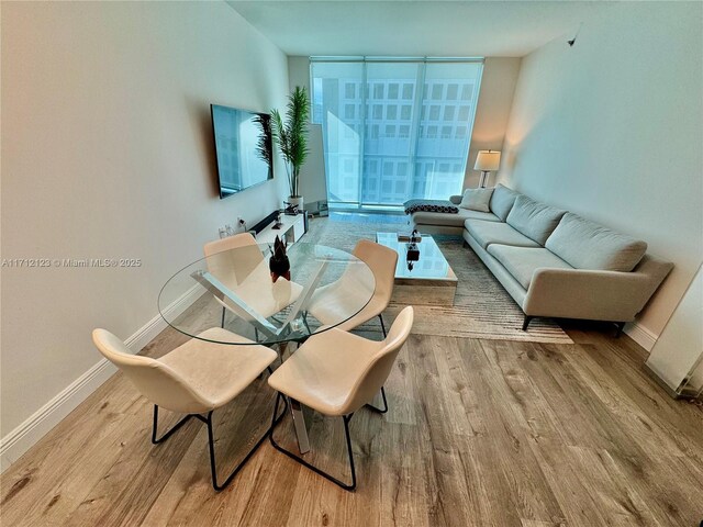 dining room featuring a wall of windows and light wood-type flooring