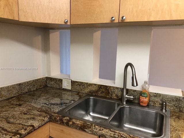 interior details with dark stone countertops and sink