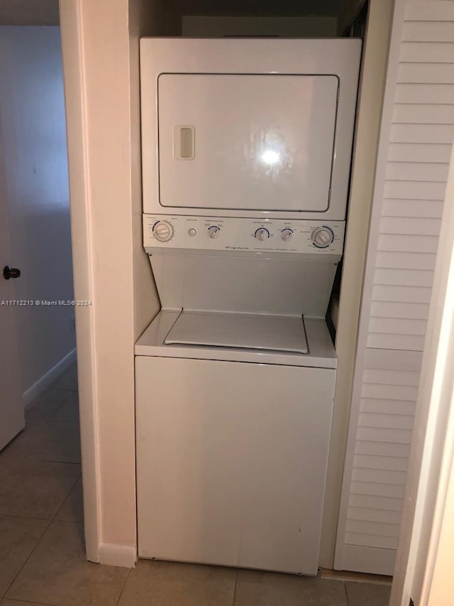 laundry area with tile patterned floors and stacked washer / dryer