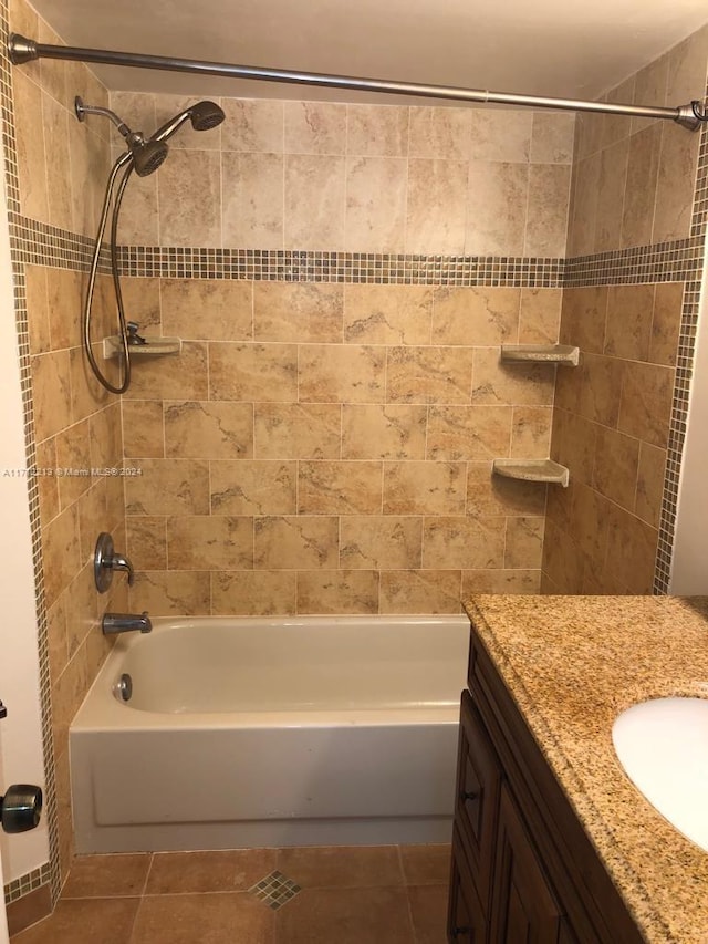 bathroom with tile patterned floors, vanity, and tiled shower / bath