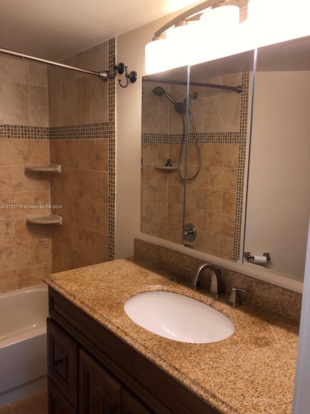 bathroom featuring vanity and tiled shower / bath