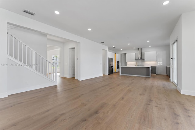 unfurnished living room featuring light hardwood / wood-style floors and sink