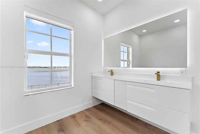 bathroom featuring wood-type flooring, vanity, and a water view