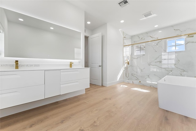 bathroom with shower with separate bathtub, vanity, and hardwood / wood-style floors