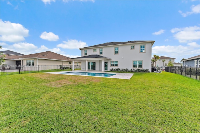 back of property featuring a fenced in pool, a patio area, and a yard