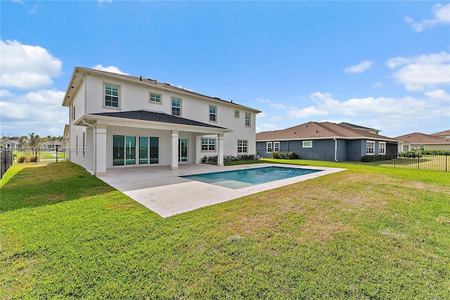 back of property featuring a patio, a fenced in pool, and a lawn