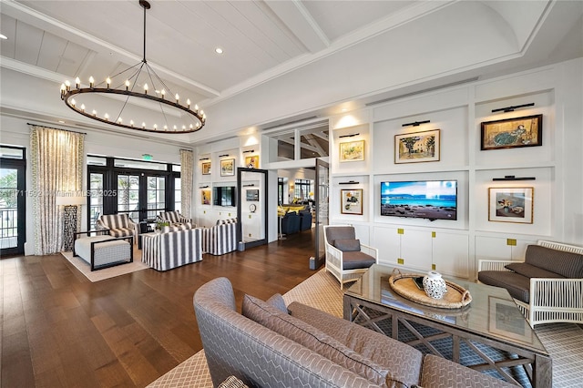 living room featuring a chandelier, beam ceiling, ornamental molding, and french doors